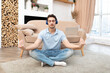 © Vitaliy - Young handsome man wearing headphones, sitting on the floor and meditating. Meditation with music concept