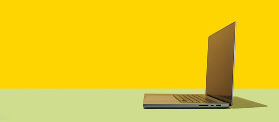 Bright yellow-green background with a laptop