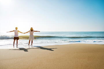 Wall Mural - Young couple embracing enjoying ocean on beach.