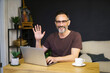 © ReyRomMedia - Bearded businessman working at home with laptop, drinking coffee at desk in living room