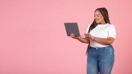 Wall Mural - Happy Black Obese Woman Using Laptop Websurfing On Pink Background