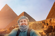 Happy man tourist on background pyramids of Giza in Cairo Egypt sunset sky, travel Egyptian