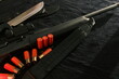 © Babenko - Weapon on black cloth: knife, rifle, shells,top view. Top view of knife, rifle, shells.