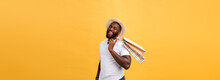 Happy African American Man Holding Shopping Bags On Yellow Background. Holidays Concept