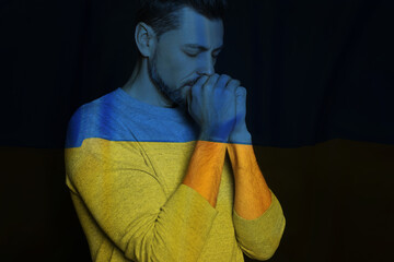 Wall Mural - Double exposure of national flag and man praying. Stop war in Ukraine