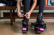© Scopio - Woman sitting on bench and putting on her kangoo shoes