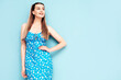 © halayalex - Portrait of young beautiful smiling female in trendy summer dress. Sexy carefree woman posing near blue wall in studio. Positive model having fun and going crazy. Cheerful and happy