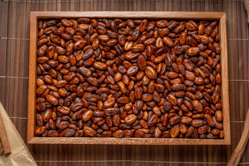 Cocoa beans on wooden plate, Aromatic, Roasted Cocoa beans in wooden background.