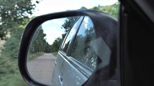 Automotive Theme
Traveling By Car
View Through The Window Of A Moving Car On The Rearview Mirror In Which We See A Small Narrow Road Between Trees