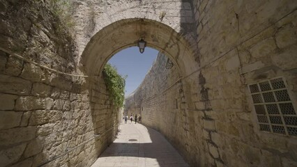 Wall Mural - People Walking Through Stone Archway Within The Western Wall In Old City Of Jerusalem In Israel. - POV