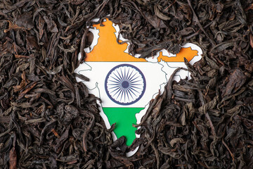 Canvas Print - Flag and map of India surrounded by black tea leaves. Concept of trade of tea in India