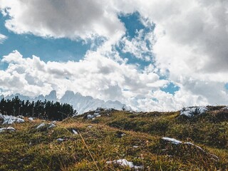 Sticker - Beautiful view of a dry hillside with rocky mountains and fluffy clouds in the background