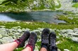 Closeup of two pairs of mountain climbing boots against river and rocky valley