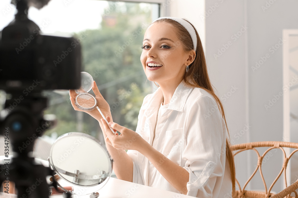 Young beauty blogger with highlighter recording video in dressing room
