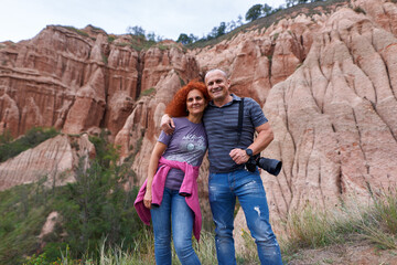 Wall Mural - Happy couple with camera in a mountain holiday