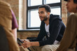 © pressmaster - Young man with post traumatic syndrome in casualwear sitting among other patints of psychotherapist during discussion of their problems