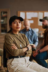 Wall Mural - Young depressed Hispanic woman with military dog tag on ball chain hanging on her neck looking at camera during psychological session