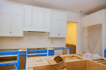 Wall Mural - Installation of white kitchen cabinets furniture interior with newly constructed house