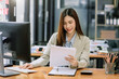 © Nuttapong punna - Asian businesswoman working in the office with working notepad, tablet and laptop documents .