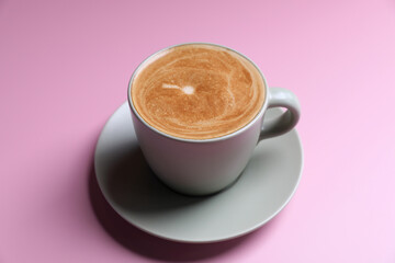 Wall Mural - hot cappuccino with latte art isolated in pink background