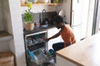 © wavebreak3 - Happy african american man celaning, unloading dishwasher in kitchen