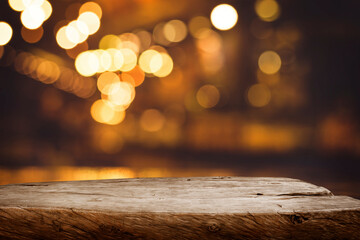 Wall Mural - Selective focus.Wood table top with blur light bokeh in dark night cafe,restaurant background.