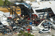 Leinwandbild Motiv Hurricane Ian destroyed industrial building with damaged cars under ruins in Florida. Natural disaster and its consequences