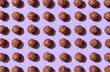 Chocolate candies aligned on a purple background. Chocolate truffles pattern