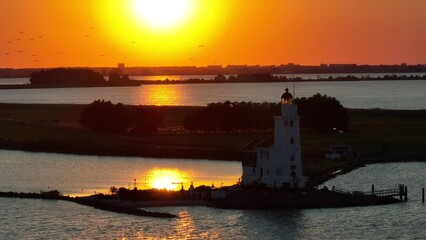 Wall Mural - Cinematic 4k aerial video of setting sun at the Paard van Marken lighthouse at the Markermeer in the Netherlands