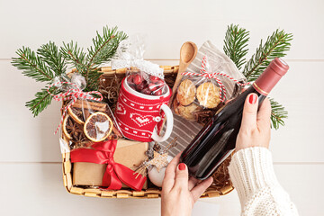 Refined Christmas gift basket for culinary enthusiats with bottle of wine and mulled wine ingredients. Corporate hamper or personal present for cooking lovers, foodies and gourmands.