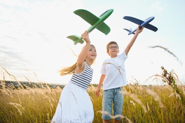 Wall Mural - Active running kids with boy holding airplane toy.