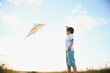 © Serhii - Children launch a kite in the field at sunset.
