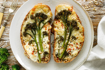 Wall Mural - Grilled sandwiches, toasts with baby broccoli, cheese and pine nuts on a plate, top view