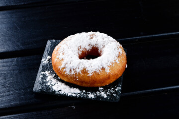 Wall Mural - Delicious donuts with powdered sugar on wooden table