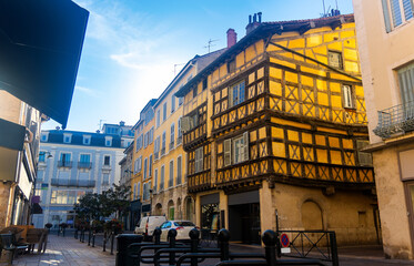 Wall Mural - Traditional architecture of Bourg-en-Bresse. View of medieval half-timbered house at intersection of narrow streets in small French town on summer day