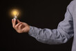 © New Africa - Glow up your ideas. Closeup view of man holding light bulb on black background