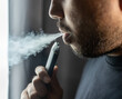 Close-up mouth of man smoke inhaling, breathing and smoke electronic cigarette.