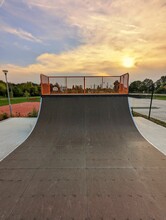 Vertical Shot Of Half Pipe In A Skate Park On Bright Sunset Sky Background