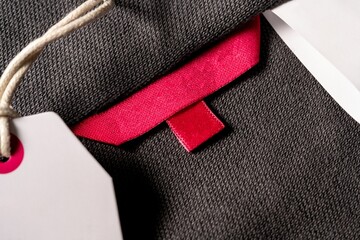 Closeup shot of a blank red fabric tag on a cloth for a size label