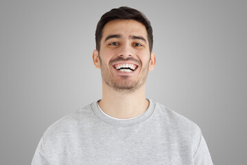 Wall Mural - Close-up of handsome smiling broadly unshaven young man laughing out loud