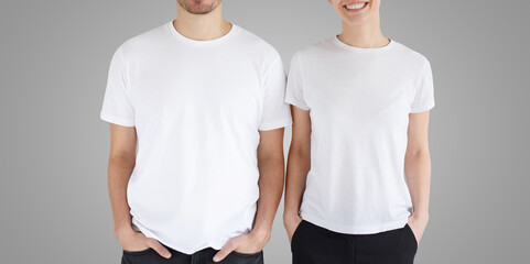 Wall Mural - Young smiling couple in blank white t-shirts isolated on gray