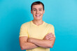 © Tetiana - Portrait of smiling cool man in t shirt having his arms crossed looking at camera isolated on blue color background