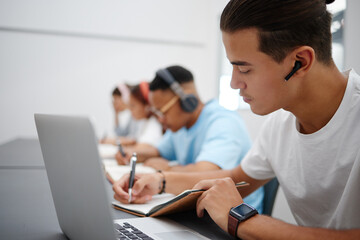 Poster - Studying, notebook and laptop with students in university classroom, library or workspace for learning, education and exam. Young college people writing lecture notes, research and digital technology