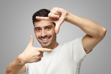 Guy holding fingers in frame as if willing to take photo of something inspiring