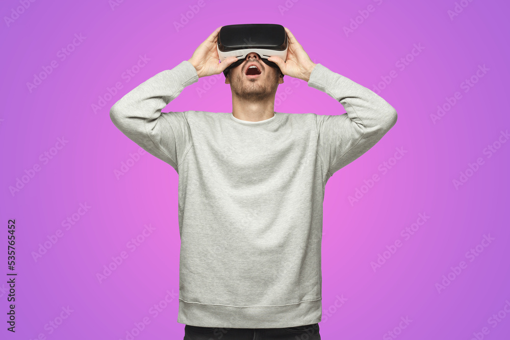 Astonished man experiencing virtual reality using VR headset for entertaining