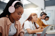 © Siphosethu Fanti/peopleimages.com - Education, headphones and black woman in university on laptop, typing notes and studying for test. Learning, college and female listening to music, educational podcast or radio working on project.