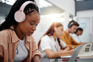 Leinwandbilder - Education, headphones and black woman in university on laptop, typing notes and studying for test. Learning, college and female listening to music, educational podcast or radio working on project.