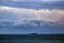 A Lonely Ship Under A Cloudy Sky Stands On The Horizon In The Black Sea	
