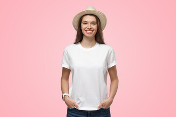 Wall Mural - Relaxed smiling girl in summer hat isolated on pink background