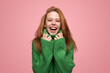 Delighted young lady in sweater laughing at camera in pink studio